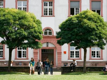 Gebäude der Philosophischen Fakultät mit Studierenden im Vordergrund